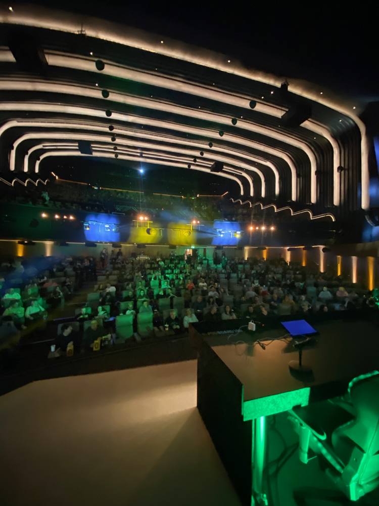 Conference hall lit for a live podcast stage